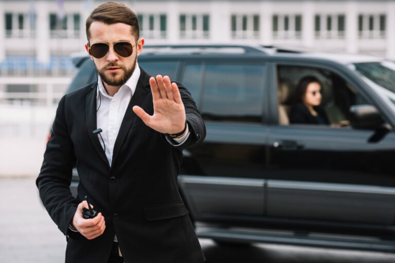 A man in a suit and sunglasses waves at the camera, embodying professionalism and confidence in commercial security.