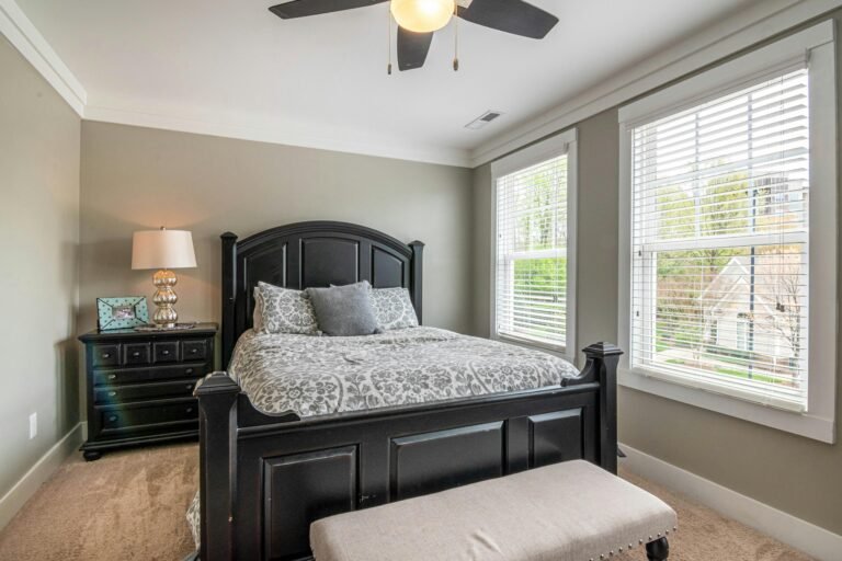 A stylish bedroom with a firm king bed and a ceiling fan, enhancing sleep quality with Top Sleep Solutions.